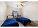 Bright bedroom with ceiling fan, window, and two beds with blue comforters at 3641 Stokes Dr, Sarasota, FL 34232