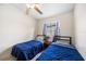 Bright bedroom with ceiling fan, window, and two beds with blue comforters at 3641 Stokes Dr, Sarasota, FL 34232