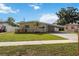 Lovely single-story home with a covered carport, a vibrant green lawn, and mature trees at 3641 Stokes Dr, Sarasota, FL 34232