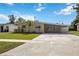 Inviting single-story home with a long driveway and a beautifully manicured lawn at 3641 Stokes Dr, Sarasota, FL 34232