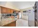 Well-lit kitchen features stone countertops, wood cabinetry, and stainless-steel appliances at 3641 Stokes Dr, Sarasota, FL 34232