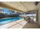 A covered, screened patio with a dining set overlooks the sparkling pool and tropical landscaping at 3641 Stokes Dr, Sarasota, FL 34232