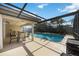 A covered, screened patio with a dining set overlooks the sparkling pool at 3641 Stokes Dr, Sarasota, FL 34232