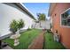 Well-kept backyard featuring artificial turf, a beautiful fountain, and a charming garden pathway at 3957 Proctor Rd, Sarasota, FL 34233