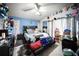 Bedroom featuring blue accent wall, ceiling fan and playful stuffed animal decorations at 3957 Proctor Rd, Sarasota, FL 34233