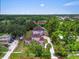 An aerial view of the pink two-story home showing the property lines, yard, and surrounding trees and neighborhood at 4105 37Th E St, Bradenton, FL 34208
