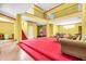 Spacious basement featuring vibrant yellow walls, red carpet and unique multi-level design at 4105 37Th E St, Bradenton, FL 34208