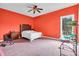 Bedroom features orange walls, ceiling fan, window with view to the outside, and carpet at 4105 37Th E St, Bradenton, FL 34208