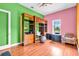 Vibrant bedroom with wood floors, a playful mix of green and pink walls, plus ample storage at 4105 37Th E St, Bradenton, FL 34208