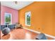Bright bedroom featuring hardwood floors, multiple windows, and unique orange and pink walls at 4105 37Th E St, Bradenton, FL 34208