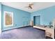 Bedroom with blue walls and carpet, ceiling fan, closet, and large window at 4105 37Th E St, Bradenton, FL 34208
