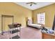 Bedroom features yellow walls, pink carpet, small bed, and clothing rack at 4105 37Th E St, Bradenton, FL 34208
