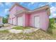 Eye-catching pink exterior of this house featuring a three-car garage and side entry door at 4105 37Th E St, Bradenton, FL 34208