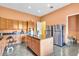 Open concept kitchen with island, granite countertops, stainless steel refrigerator, and wood cabinets at 4105 37Th E St, Bradenton, FL 34208