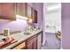 Kitchenette featuring dark wood cabinets, granite countertop, stainless steel sink, and lavender walls at 4105 37Th E St, Bradenton, FL 34208