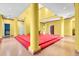 A yellow living room with pillars, red carpeted stage, tiled floors, open loft, and high ceilings at 4105 37Th E St, Bradenton, FL 34208