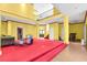 An open concept yellow living room with red carpeted stage, tiled floors, high ceilings and a partial view of the loft at 4105 37Th E St, Bradenton, FL 34208