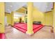 A yellow living room with pillars, red carpeted stage, tiled floors, open loft, high ceilings and several sitting areas at 4105 37Th E St, Bradenton, FL 34208