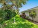 Well-maintained backyard features a manicured lawn, lush hedges and trees providing privacy, with a white house at 4203 Schwalbe Dr # 115, Sarasota, FL 34235
