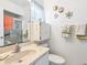 Bathroom featuring tile shower, sink vanity, toilet, and decorative elements at 4203 Schwalbe Dr # 115, Sarasota, FL 34235