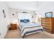 Cozy bedroom featuring a large window, carpeted floors, ceiling fan, a comfortable bed and wooden furniture at 4203 Schwalbe Dr # 115, Sarasota, FL 34235