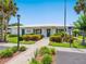 Exterior view of a community building with a well-manicured garden and palm trees at 4203 Schwalbe Dr # 115, Sarasota, FL 34235