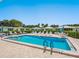 Inviting community pool surrounded by lounge chairs and lush greenery, creating a serene outdoor oasis at 4203 Schwalbe Dr # 115, Sarasota, FL 34235
