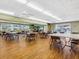 Large community room with bright lighting, tables, chairs, and a TV, next to a view of the pool at 4203 Schwalbe Dr # 115, Sarasota, FL 34235
