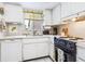 Bright kitchen features white cabinets, appliances, and countertops with a garden window above the sink at 4203 Schwalbe Dr # 115, Sarasota, FL 34235
