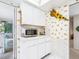 Bright kitchen with white cabinets, marble countertops, sunflower decor, microwave, and adjacent dining area at 4203 Schwalbe Dr # 115, Sarasota, FL 34235