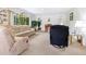 Spacious living room with large windows, plush seating, and views of lush greenery at 4203 Schwalbe Dr # 115, Sarasota, FL 34235