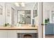 Bright bathroom vanity with a large mirror and decorative accents, plus a view into the living space at 4411 46Th W Ave # 201, Bradenton, FL 34210
