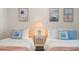 Bedroom with two twin beds, a small side table with a lamp and coastal themed art pieces at 4411 46Th W Ave # 201, Bradenton, FL 34210
