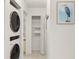 Laundry area featuring a stacked washer/dryer unit and storage shelves for convenience at 4411 46Th W Ave # 201, Bradenton, FL 34210