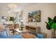 Bright living room featuring a modern chandelier and wall-mounted TV with scenic view at 4411 46Th W Ave # 201, Bradenton, FL 34210