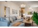 Bright living room featuring a plush sectional sofa, modern chandelier, and decorative wall art at 4411 46Th W Ave # 201, Bradenton, FL 34210