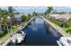 Aerial view of a canal with boats docked along the sides, surrounded by houses and palm trees at 4735 Starboard Dr, Bradenton, FL 34208