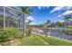 Green backyard with boats docked on a waterfront canal, surrounded by tropical landscaping at 4735 Starboard Dr, Bradenton, FL 34208