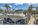 Boat on a lift on a canal with lush landscaping and beautiful houses in the background at 4735 Starboard Dr, Bradenton, FL 34208