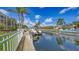 Boat docked along a canal with lush green landscaping and palm trees, perfect for waterfront living at 4735 Starboard Dr, Bradenton, FL 34208