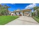Beautiful single Gathering home with attached carport, lush landscaping, and a well-maintained lawn at 4735 Starboard Dr, Bradenton, FL 34208