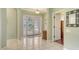 Bright and open foyer features neutral tile flooring, a decorative light fixture, and an elegant foyer table at 4735 Starboard Dr, Bradenton, FL 34208