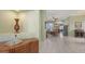 Spacious foyer with white tile floors leading to the dining room, with decorative cabinet and accessories at 4735 Starboard Dr, Bradenton, FL 34208