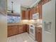 Well-lit kitchen featuring wooden cabinets, granite countertops, and white appliances for a modern cooking experience at 4735 Starboard Dr, Bradenton, FL 34208