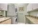Efficient laundry room with stacked washer/dryer, granite countertop, storage cabinets, and integrated sink at 4735 Starboard Dr, Bradenton, FL 34208