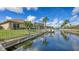 Waterfront view of a house along a canal with a boat dock and lush green landscaping at 4735 Starboard Dr, Bradenton, FL 34208