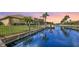 Beautiful waterfront home featuring lush landscaping, a private dock, and picturesque sunset views over the serene canal at 4735 Starboard Dr, Bradenton, FL 34208