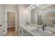 Bathroom boasts dual sinks, modern lighting, and a glass-enclosed shower, combining style and functionality at 491 Daylily Blvd, Nokomis, FL 34275