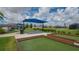 Well-maintained bocce ball courts with shade canopy and community seating overlooking the adjacent lake at 491 Daylily Blvd, Nokomis, FL 34275