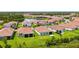 Aerial view of a community home with screened in patio, lush lawn and tile roof at 491 Daylily Blvd, Nokomis, FL 34275
